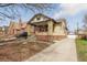 Charming brick home featuring a covered porch, tidy landscaping, and a detached garage at 1454 Utica St, Denver, CO 80204
