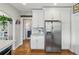 Kitchen features stainless steel refrigerator, white cabinets, and hardwood floors at 1454 Utica St, Denver, CO 80204
