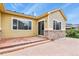 Back patio with textured concrete, yellow siding, stone details, and sliding glass door at 297 N Coolidge Way, Aurora, CO 80018