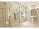 Bright bathroom featuring a glass-enclosed shower, pedestal sink, tiled floor, and a window for natural light at 297 N Coolidge Way, Aurora, CO 80018