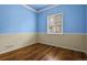 Spacious bedroom with hardwood floors, blue walls, and a large window at 297 N Coolidge Way, Aurora, CO 80018