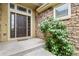 Inviting front entrance featuring a stone facade, covered porch, and a stylish multi-paneled front door at 297 N Coolidge Way, Aurora, CO 80018