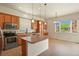 Bright kitchen features an island with granite countertop, stainless steel appliances, and tile floors at 297 N Coolidge Way, Aurora, CO 80018