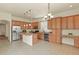 Well-lit kitchen with wood cabinets, stainless steel appliances, an island, and a cozy dining area at 297 N Coolidge Way, Aurora, CO 80018