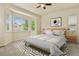 Staged main bedroom features large windows with neighborhood views, soft carpet and modern decor at 297 N Coolidge Way, Aurora, CO 80018