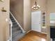 Inviting foyer with hardwood floors, staircase, coat closet and modern chandelier at 5261 S Malta Way, Centennial, CO 80015