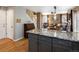 Modern kitchen with gray cabinets, granite countertops, wood floors and open floor plan at 5261 S Malta Way, Centennial, CO 80015