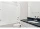 Clean bathroom with white tile, a tub, and dark vanity at 13805 Emerald Lake St, Parker, CO 80138