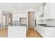 Modern kitchen with white cabinets, large island, and wood flooring at 13805 Emerald Lake St, Parker, CO 80138