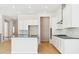 Bright kitchen features stainless steel appliances, white cabinets, and an island with dark countertop at 13805 Emerald Lake St, Parker, CO 80138