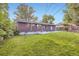 Large backyard featuring a concrete patio, manicured lawn, and brick home exterior at 2982 S Vrain St, Denver, CO 80236