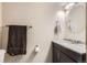 Bathroom featuring a dark vanity, light granite countertop, modern light fixture and decorative towel bar at 2982 S Vrain St, Denver, CO 80236
