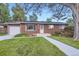 Charming single-story brick home with a well-manicured lawn and walkway at 2982 S Vrain St, Denver, CO 80236