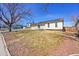 Cozy single-story home with solar panels, a yard with rock cover and mature trees at 1205 S Argonne Cir, Aurora, CO 80017