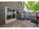 Backyard of a brick house with wooden patio, privacy fence, and sliding glass doors to the home's interior at 8023 Wolff St # C, Westminster, CO 80031
