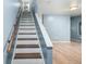 Staircase with wooden banister and neutral colored wall at 8023 Wolff St # C, Westminster, CO 80031