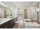 Luxurious bathroom with double vanities, a soaking tub, and a view to the bedroom at 863 Edenborn Pl, Castle Rock, CO 80104