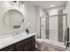 Modern bathroom with a round mirror, tile shower, and dark vanity at 863 Edenborn Pl, Castle Rock, CO 80104