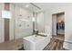 Spa-like bathroom featuring a modern soaking tub, a glass-enclosed shower, and elegant tile work at 863 Edenborn Pl, Castle Rock, CO 80104