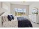 Bright bedroom with a large window, a cozy bed, and a stylish dresser for a comfortable and inviting space at 863 Edenborn Pl, Castle Rock, CO 80104