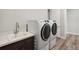 Well-equipped laundry room with modern washer and dryer, a sink, and ample counter space for convenience at 863 Edenborn Pl, Castle Rock, CO 80104