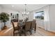 Elegant dining room with modern chandelier, sleek table setting, and a sunlit window at 6690 S Sheridan Blvd, Littleton, CO 80123
