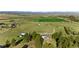 An aerial view of the property featuring a home, outbuildings, and a lush green landscape, framed by trees at 10522 Bayou Gulch Rd, Parker, CO 80134