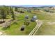 Aerial view of the property featuring multiple outbuildings and a barn set on a sprawling green lot at 10522 Bayou Gulch Rd, Parker, CO 80134
