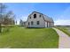 Exterior of a barn with white siding, a metal roof, garage doors, and a walkway across a green lawn at 10522 Bayou Gulch Rd, Parker, CO 80134