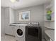 Well-lit laundry room with washer, dryer, built-in shelves and storage at 10522 Bayou Gulch Rd, Parker, CO 80134