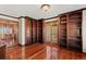 Office featuring built-in wooden bookshelves, wood flooring, and double French doors at 10522 Bayou Gulch Rd, Parker, CO 80134