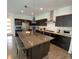 Modern kitchen with stainless steel appliances, dark cabinets, and a large center island with seating at 9603 Dunning Cir, Highlands Ranch, CO 80126