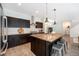 Stylish kitchen featuring dark wood cabinets, stainless steel appliances, and a large island with barstool seating at 9603 Dunning Cir, Highlands Ranch, CO 80126