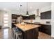 Modern kitchen featuring stainless steel appliances, dark wood cabinetry, and a large center island with seating at 9603 Dunning Cir, Highlands Ranch, CO 80126