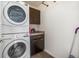 Efficient laundry room features stacked washer and dryer, a counter, and upper cabinets for storage solutions at 9603 Dunning Cir, Highlands Ranch, CO 80126