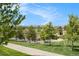 Scenic neighborhood view with lush green lawns, mature trees, and distant mountain views under a sunny blue sky at 9603 Dunning Cir, Highlands Ranch, CO 80126