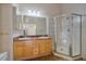 Bathroom with a glass shower, wood vanity, granite countertop, and a large mirror at 190 Roslyn St # 802, Denver, CO 80230