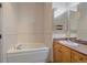 Bathroom featuring a jacuzzi tub, sink with granite countertop, and neutral tile at 190 Roslyn St # 802, Denver, CO 80230