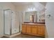 Bathroom featuring tiled shower, wood vanity, granite countertop, and a large mirror at 190 Roslyn St # 802, Denver, CO 80230