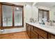 Bathroom featuring double sinks, granite countertop, wooden cabinets and a large window at 4380 Sandstone Dr, Monument, CO 80132