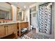 Bathroom with double sink vanity, granite countertop, natural wood cabinets, shower, and a separate toilet room at 4380 Sandstone Dr, Monument, CO 80132