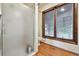 This bathroom features a glass-enclosed shower, wood flooring, and a large window, offering natural light and a spacious feel at 4380 Sandstone Dr, Monument, CO 80132