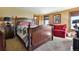 Bedroom with four-poster bed, soft carpet, red couch, and natural light, offering a cozy and inviting atmosphere at 4380 Sandstone Dr, Monument, CO 80132