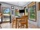 Dining area with a wooden table, three windows, and views of the trees outside at 4380 Sandstone Dr, Monument, CO 80132