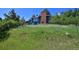 Two-story home's exterior features green siding, a brick chimney, and mature trees in a serene setting at 4380 Sandstone Dr, Monument, CO 80132