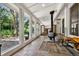 Bright sun room with large windows, tile flooring, and a cozy wood-burning stove at 4380 Sandstone Dr, Monument, CO 80132