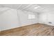 Bright basement area with laminate floors, white ceiling beams, and utility access at 4401 Quieto Ct, Denver, CO 80211