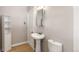 Bathroom featuring a pedestal sink, wooden flooring, and a stylish vanity mirror at 4401 Quieto Ct, Denver, CO 80211