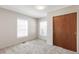 Cozy bedroom featuring plush carpet, two windows, and closet at 4401 Quieto Ct, Denver, CO 80211