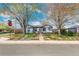 Charming single-story home with a manicured front lawn and mature trees, as viewed from the street at 4401 Quieto Ct, Denver, CO 80211